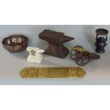 A box of interesting items to include a miniature anvil, a miniature canon, a pricket stick, a piece