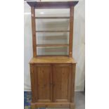 A small Georgian style stripped and waxed pine dresser, the lower section enclosed by a pair of