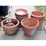 Sixteen contemporary, mainly terracotta planters of varying size and design, including some