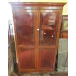 A good quality Edwardian hanging cupboard in the Sheraton manner, the doors enclosed with inlaid