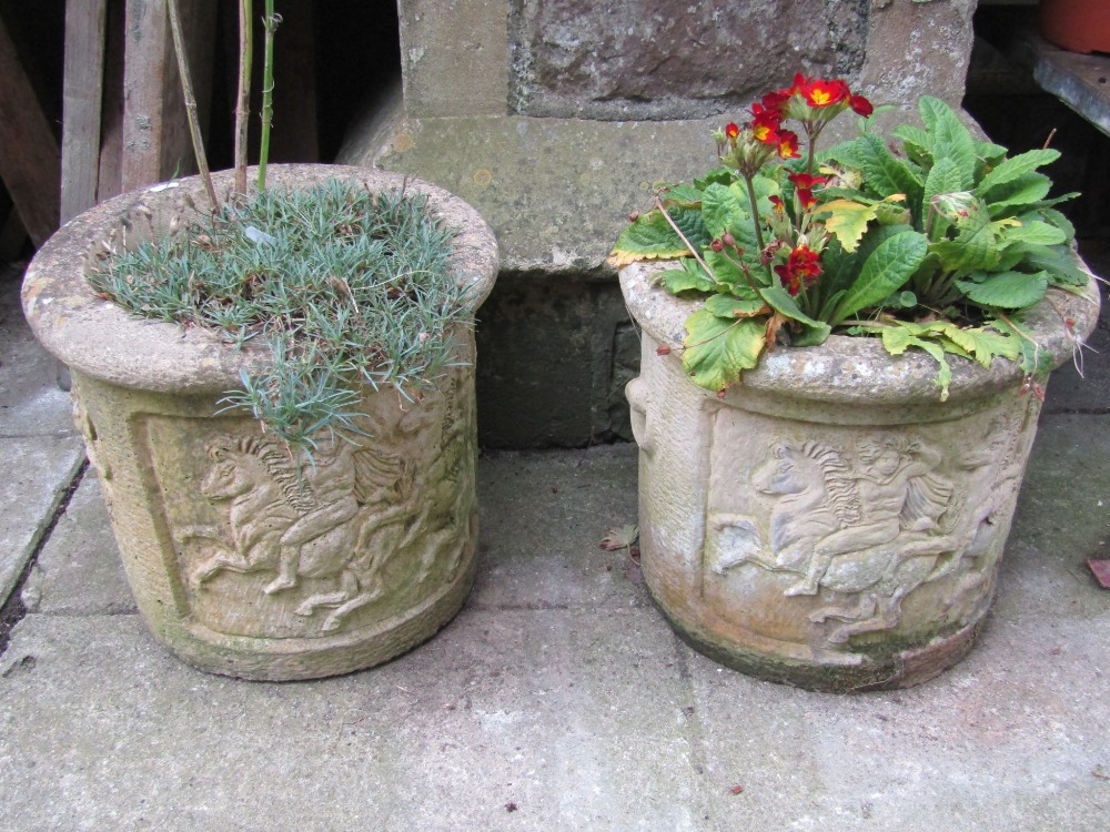 A pair of weathered contemporary composition stone planters of squat cylindrical form with raised