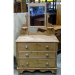 A Victorian stripped pine dressing chest with swing mirror, over three long graduated drawers with