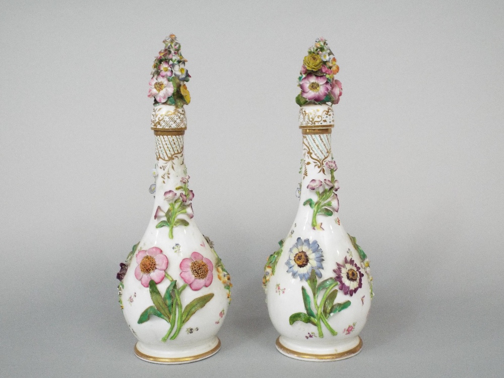 A pair of 19th century white ground bottles and stoppers of slender form with painted and