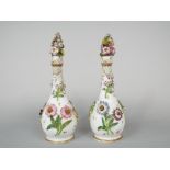A pair of 19th century white ground bottles and stoppers of slender form with painted and