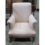 A late Victorian/Edwardian drawing room chair, with shaped outline, rolled arms and back, simply