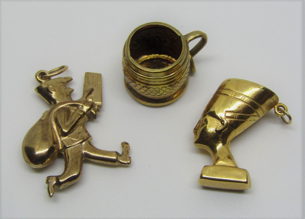 Three 9ct novelty charms comprising Nefertiti, a postman and a tankard, 6.1g total (3)