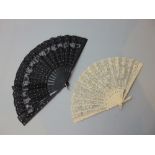 Victorian lace leaf fan, guards carved with floral trails, together with a black silk fan