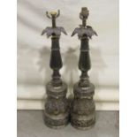 A pair of cast metal table lamps with decorative scrolling acanthus, classical swag and further