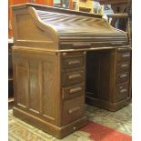 A Lebus oak kneehole twin pedestal roll top desk, the S shaped tambour roll enclosing a pigeon