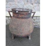 A 19th century cast iron, pot bellied, floor standing cauldron, with angular handles, banded