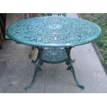 A green painted cast aluminium garden terrace table of circular form with decorative pierced