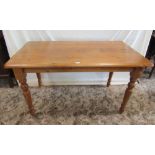 A Victorian style pine kitchen table of rectangular form with moulded outline raised on turned