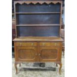 An Edwardian stained oak dresser, the base enclosed by a pair of rectangular moulded panelled