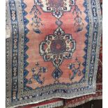 Eastern rug with twin blue medallion decoration upon a washed red ground, 200 x 150cm