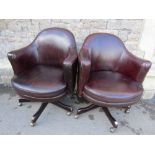 A pair of good quality swivel brown stitched leather upholstered tub chairs with arched backs and