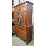 An unusual Edwardian walnut linen press, the upper section enclosed by a central oval decorative