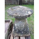 A large natural stone staddlestone of square tapered form with wide base, complete with domed cap,