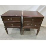 A pair of two drawer bedside chests/lamp tables of square cut and tapered form with ring pull