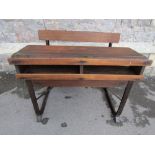 A vintage oak school desk for two pupils with bench seat, rail back and slope over a recessed twin