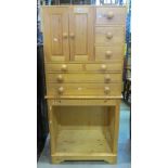 A stripped pine two sectional side cabinet, the upper fitted with an arrangement of seven drawers