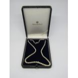 Graduated pearl necklace with silver clasp stamped 'M', with a Mikimoto box and guarantee