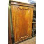 A small early 19th century continental figured walnut cupboard enclosed by a single panel door, with