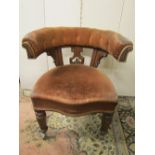 A Victorian oak framed office chair with horseshoe shaped back raised on carved supports, with