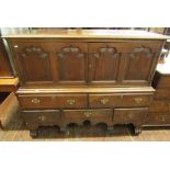 A Georgian oak chest on stand, the front elevation of four shaped and fielded panels, the base