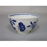 An 18th century Worcester blue and white tea bowl with floral and moth decoration and crescent