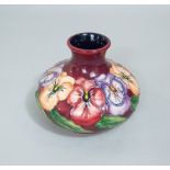 A Moorcroft puce ground vase of onion shaped form with pansy decoration and impressed marks to base,