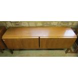 A Russell of Broadway mid 20th century teak long and low sideboard enclosed by four doors raised