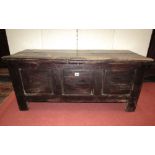 An 18th century panelled oak coffer set beneath a planked top, 110cm wide