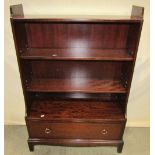 A dwarf freestanding Stag Minstrel bookcase with two adjustable shelves over a long drawer, shaped