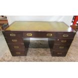 A kneehole twin pedestal writing desk in the military/campaign style with inset green leather
