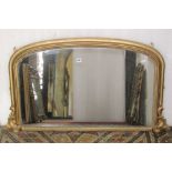 A small Victorian overmantle mirror with moulded arched gilt frame, enclosing a speckled plate,