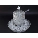 A good quality cut glass lidded punch bowl with ladle and a collection of cups, all on a cut glass