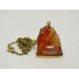 9ct necklace hung with a carved agate pendant in the form of a Buddha seated on a gold plinth with