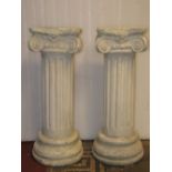 A pair of plaster pedestals in the form of architectural cylindrical reeded columns with doric