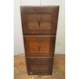 A vintage panelled oak three tier filing cabinet (in separate sections) with original brass