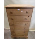 A Victorian style stripped pine chest of six long drawers raised on a moulded plinth with shaped