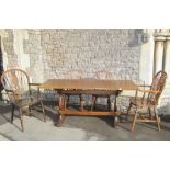 An oak refectory table, the rectangular top raised on a pair of lyre shaped supports united by a