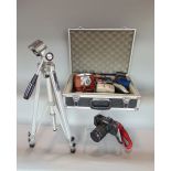 A foam lined hard travel case of camera equipment to include a Canon T70 camera, Canon zoom lens and