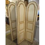 A floorstanding four fold screen/room divider, with arched panels, upholstered finish and brass