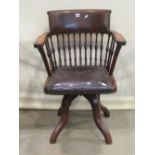 A late Victorian/Edwardian swivel office/desk chair with turned spindle and bow back over a rexine