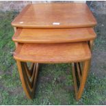 A next of three graduated Nathan teak occasional tables, with shaped outline and supports