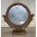 A gilt wood dressing table swing mirror of circular form with repeating foliate border and classical