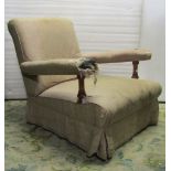 A low Victorian open armchair with shaped outline, slightly rolled head rest, upholstered finish and