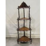 A Victorian walnut veneered freestanding corner whatnot on four graduated bow fronted tiers with