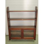 A mahogany wall mounted shelving unit, partially enclosed by a pair of rectangular glazed panel