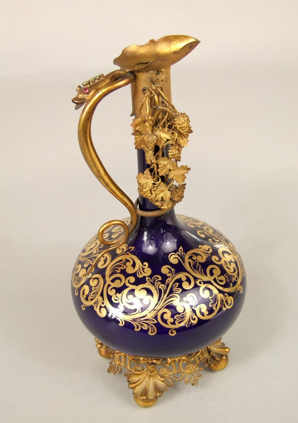 A 19th century blue ground ewer with gilded decoration and ornate gilt metal mounts and base, 22cm